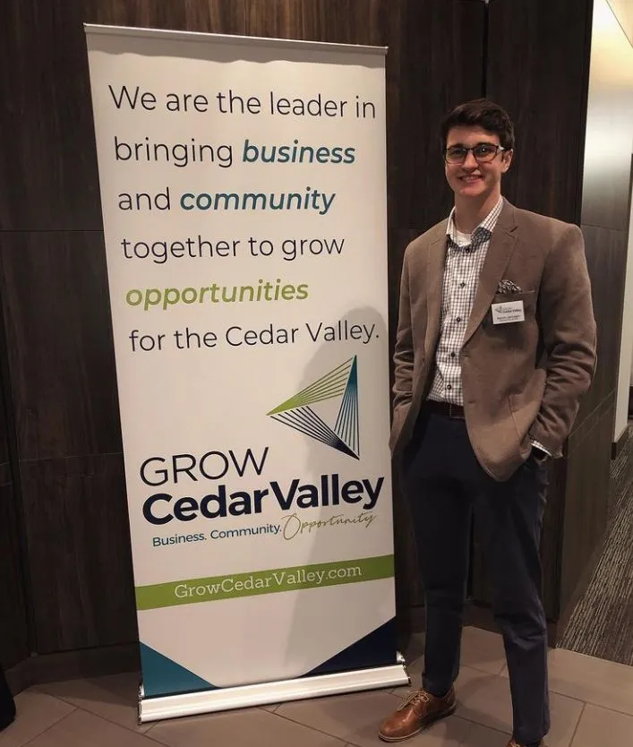 Aaron Jarnagin standing next to a Grow Cedar Valley banner